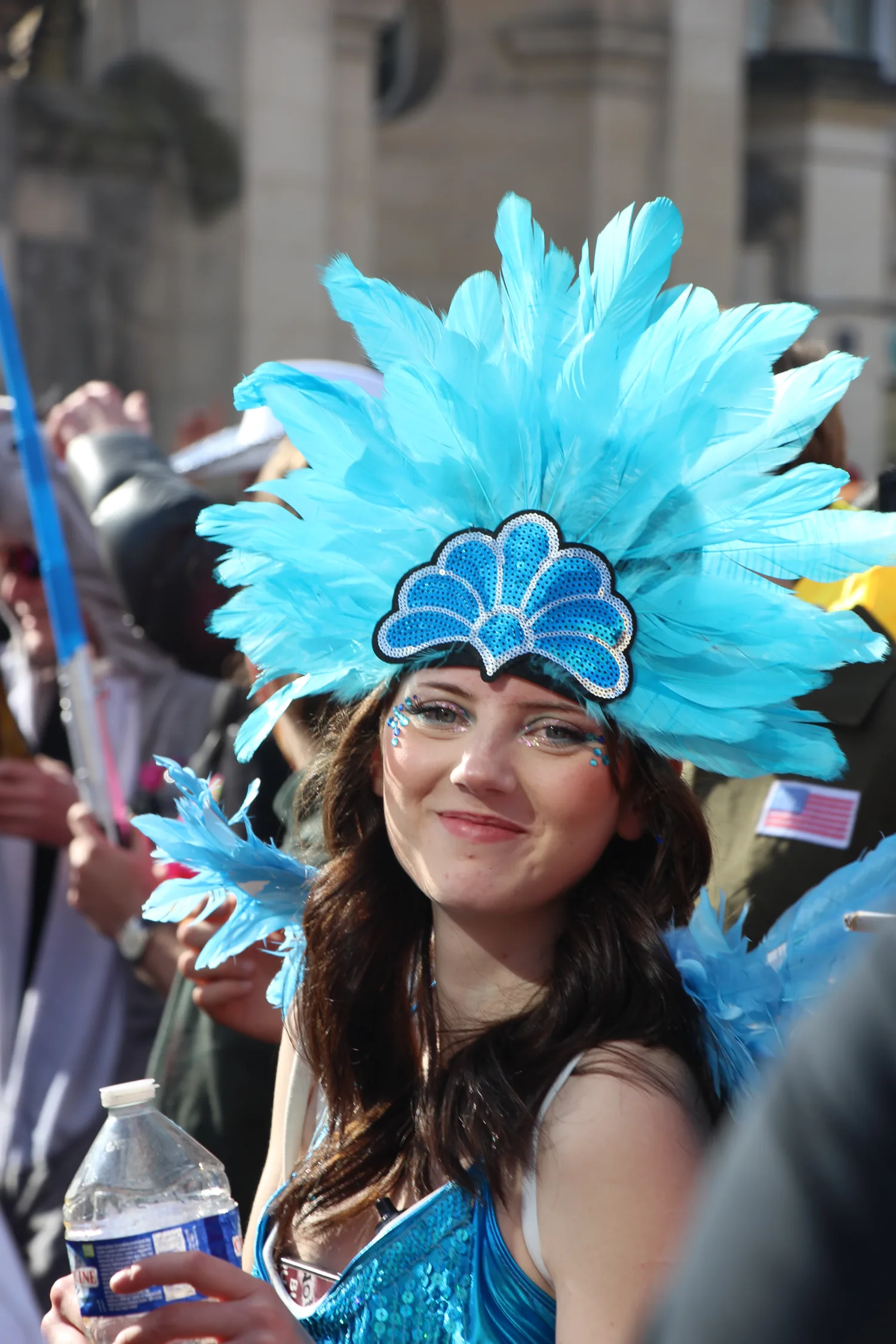 Coiffe de plumes bleue sous le soleil caennais.