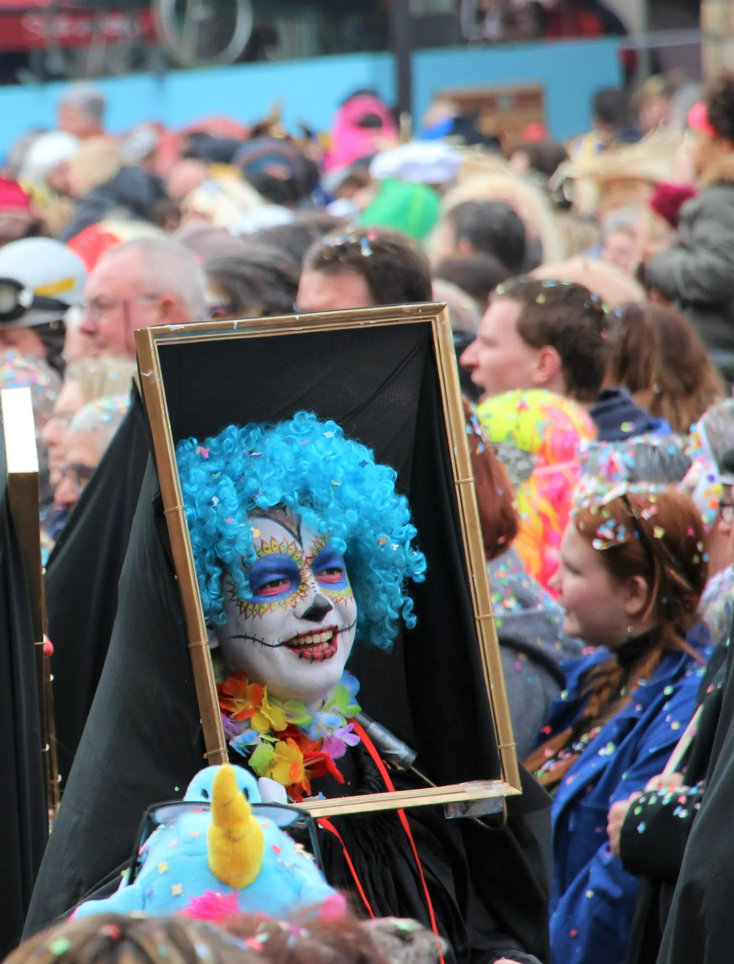 Reine de plumes au cœur de la foule en liesse.