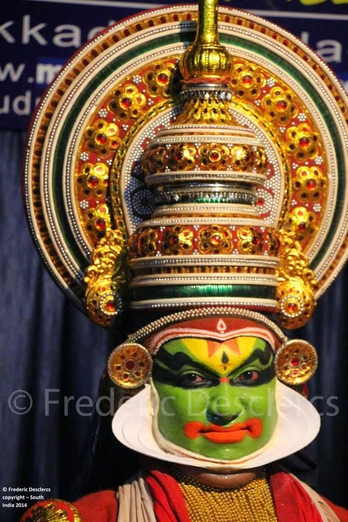 Danseur de Kathakali maquillé de vert sous sa coiffe dorée